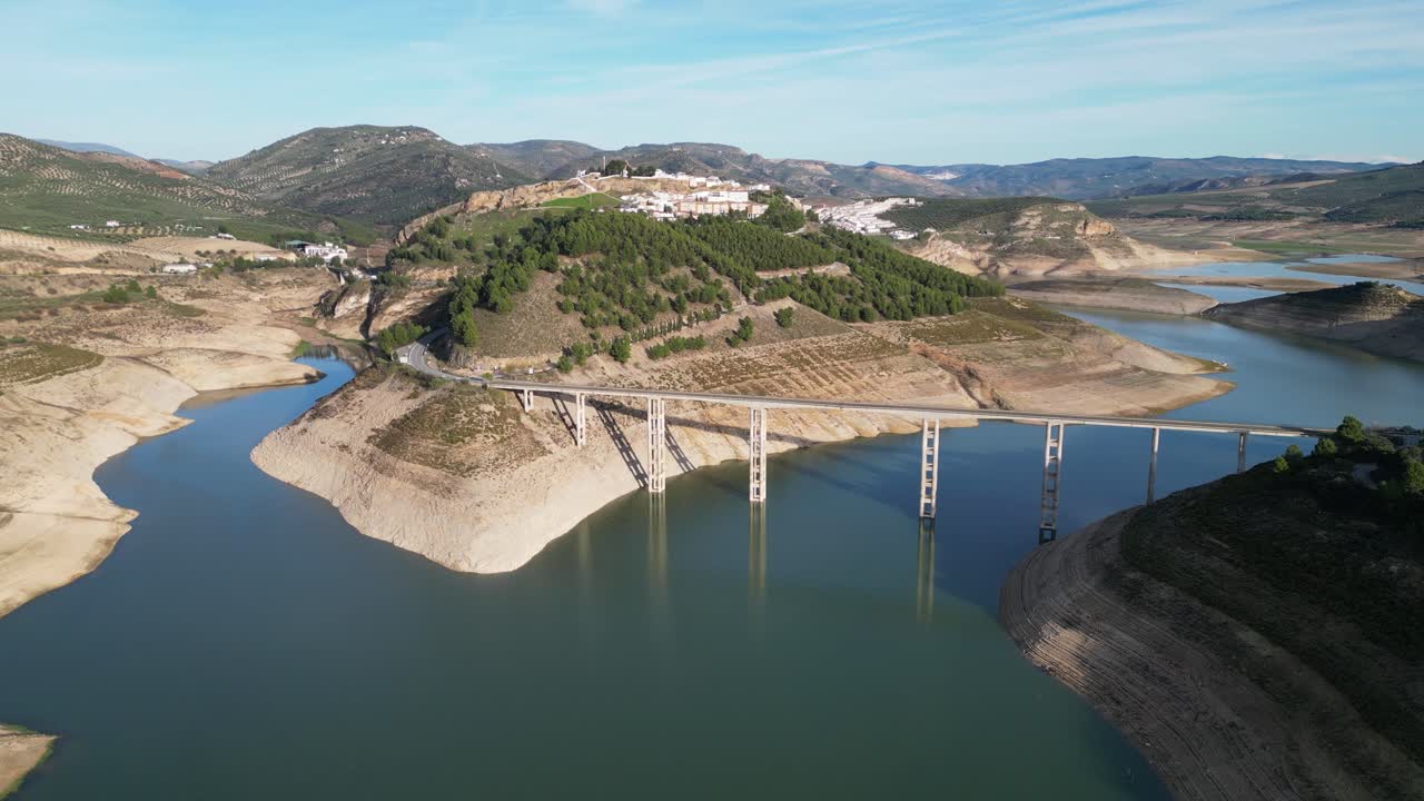 Ponte di Iznajar e villaggio di montagna in Andalusia, Spagna - Panoramica aerea 4k circolare