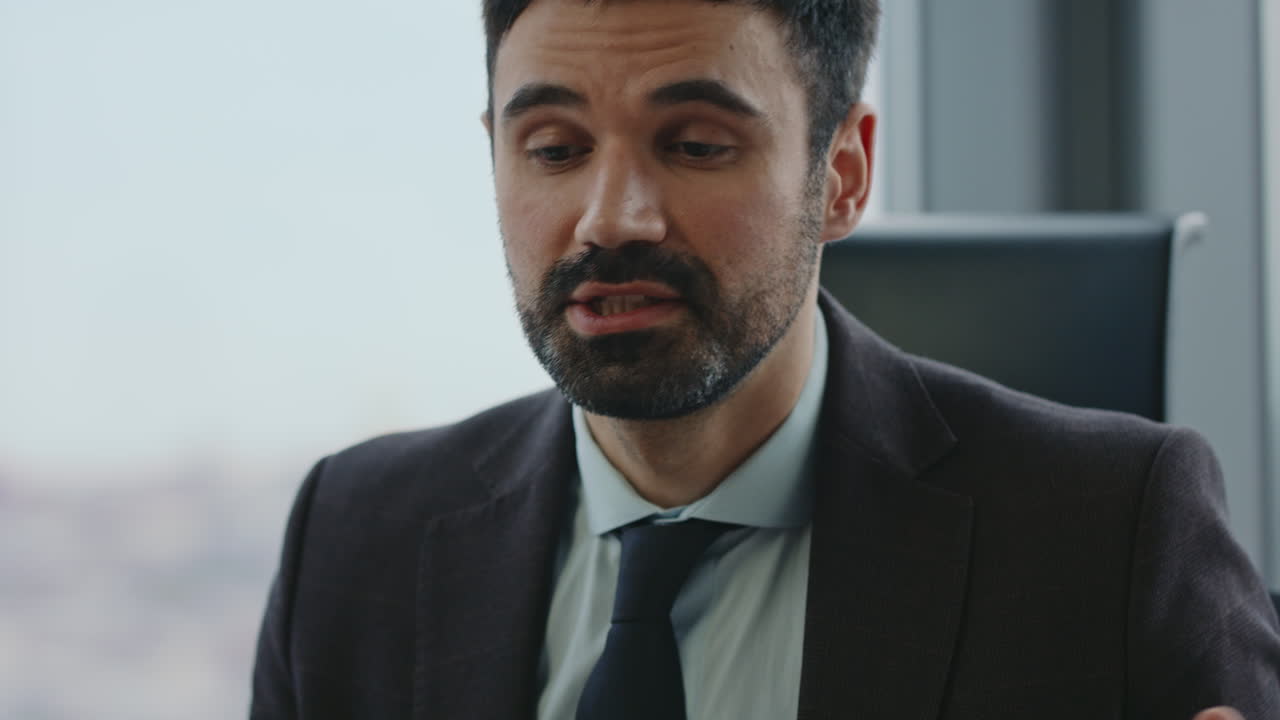 Ritratto di uomo d'affari di successo che parla in videoconferenza seduto in ufficio.
