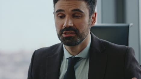 retrato de un hombre de negocios exitoso hablando en una videoconferencia sentado en la oficina.