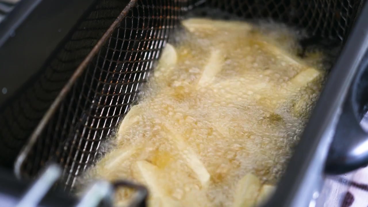 Friteuse steker pommes frites i varm olje