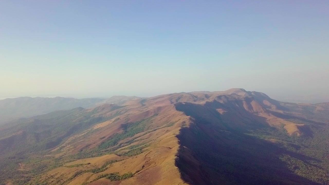 Le colline di Chikmagalur si estendono sotto un cielo sereno mostrando vasti paesaggi panoramici e un terreno accidentato