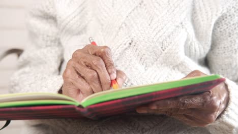 elderly woman writing in a journal