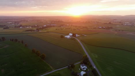 Quiet and picturesque landscape drone shot of American countryside. Golden sunset time with Main Street and farmsteads in usa. Aerial wide shot. Silo storage on homestead
