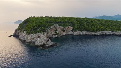 kalamota island, adriatic sea, croatia - the view of a lighthouse perched on a rugged cliff - aerial drone shot