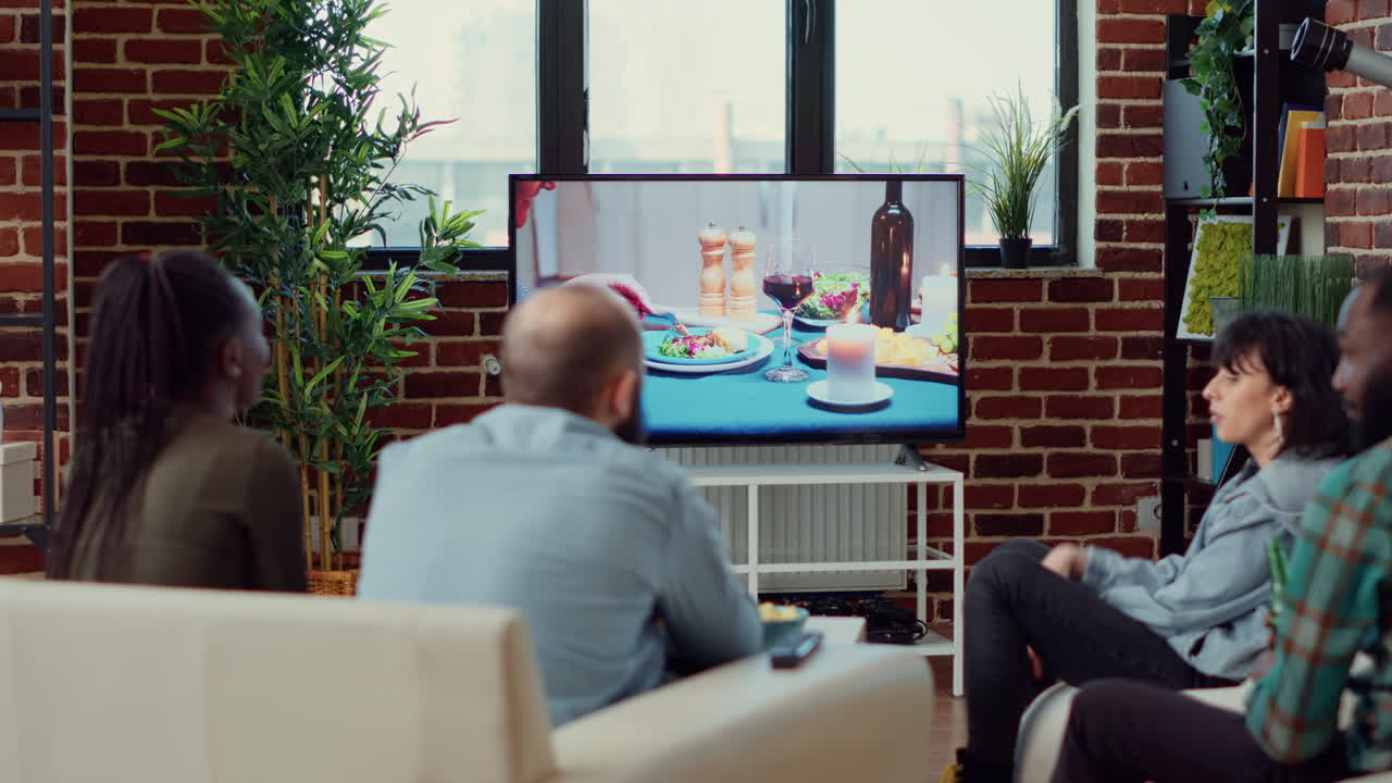 Group of friends watching drama action film on television