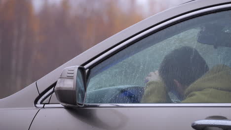 Hombre-Enojado-Y-Frustrado-Grita-Y-Llora-En-El-Auto,-Lluvia-De-Otoño,-Tiro-Cercano