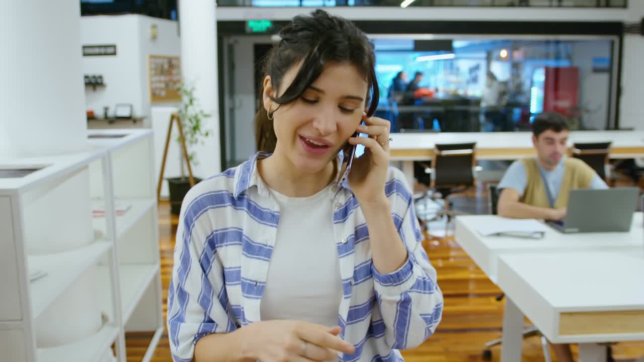 Young Businesswoman Walking in the Office and Talking on Mobile Phone