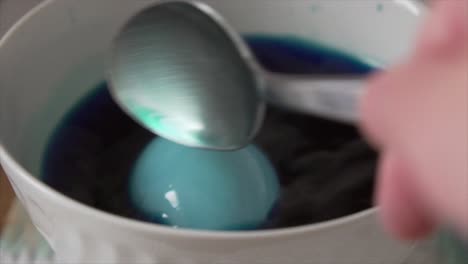 painting an egg in blue for eastern