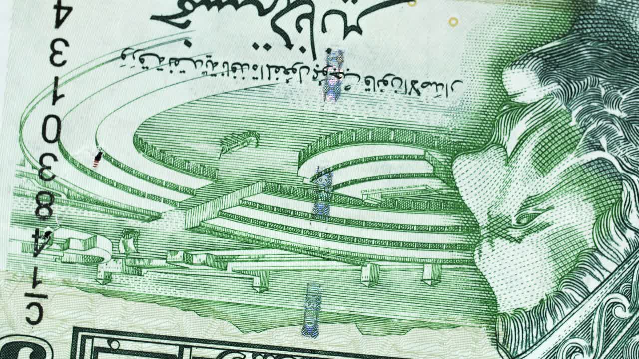 Tunisia 5 Dinar banknote obverse with Arabic script and amphitheatre engraving rotating on black background