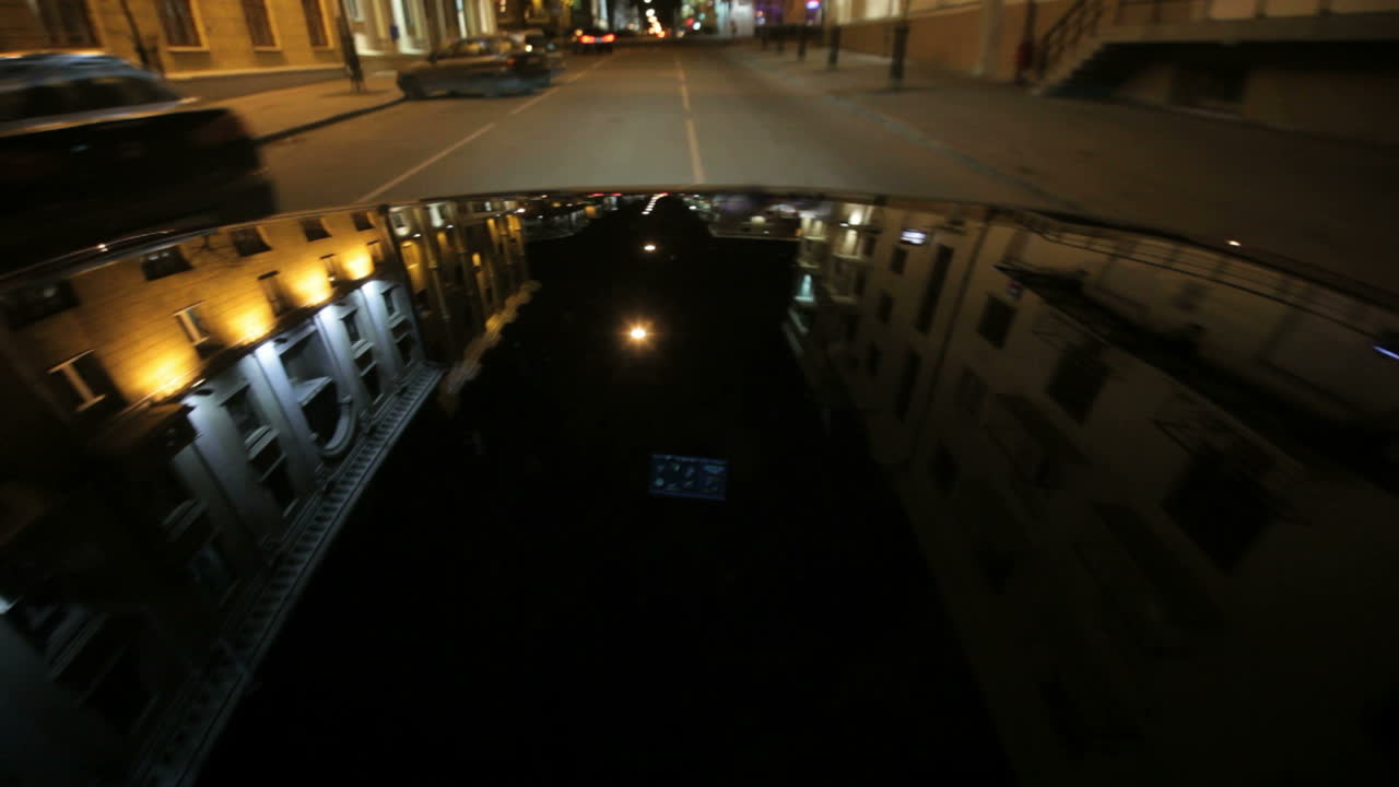 Reflejo de farolas en el capó del coche por la noche. Reflejos de luces de la ciudad en el coche.