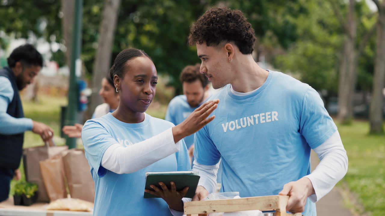 Young Volunteers Discussing Plans and Organizing Items Outdoors