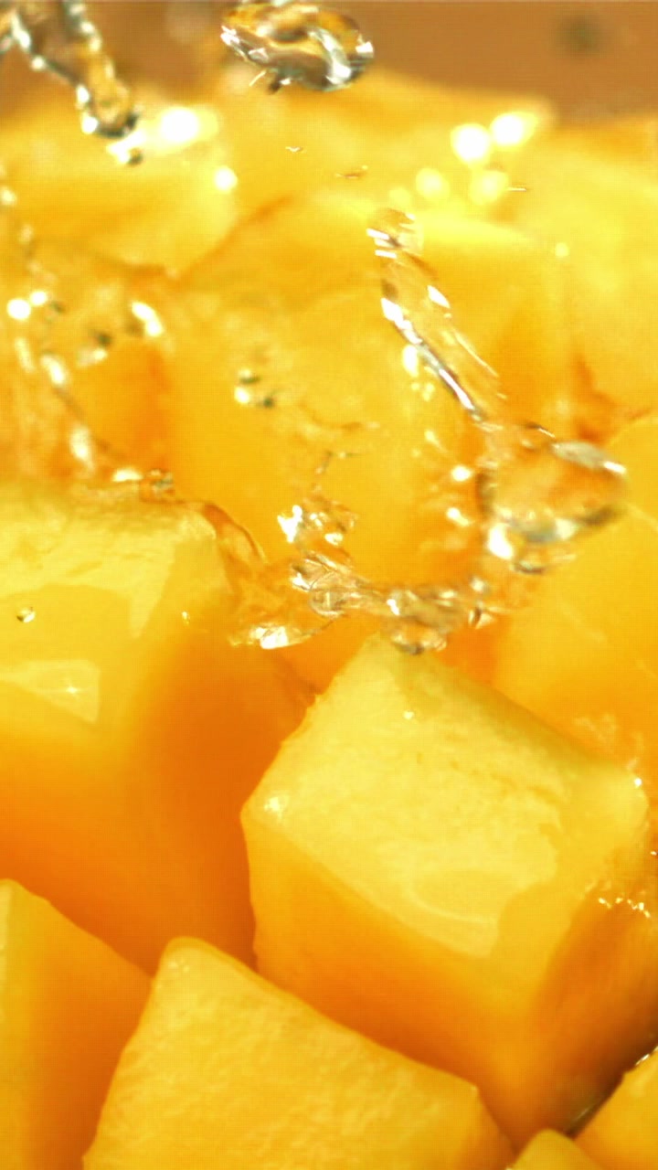 Schizzi d'acqua rinfrescante su cubetti di mango vivaci
