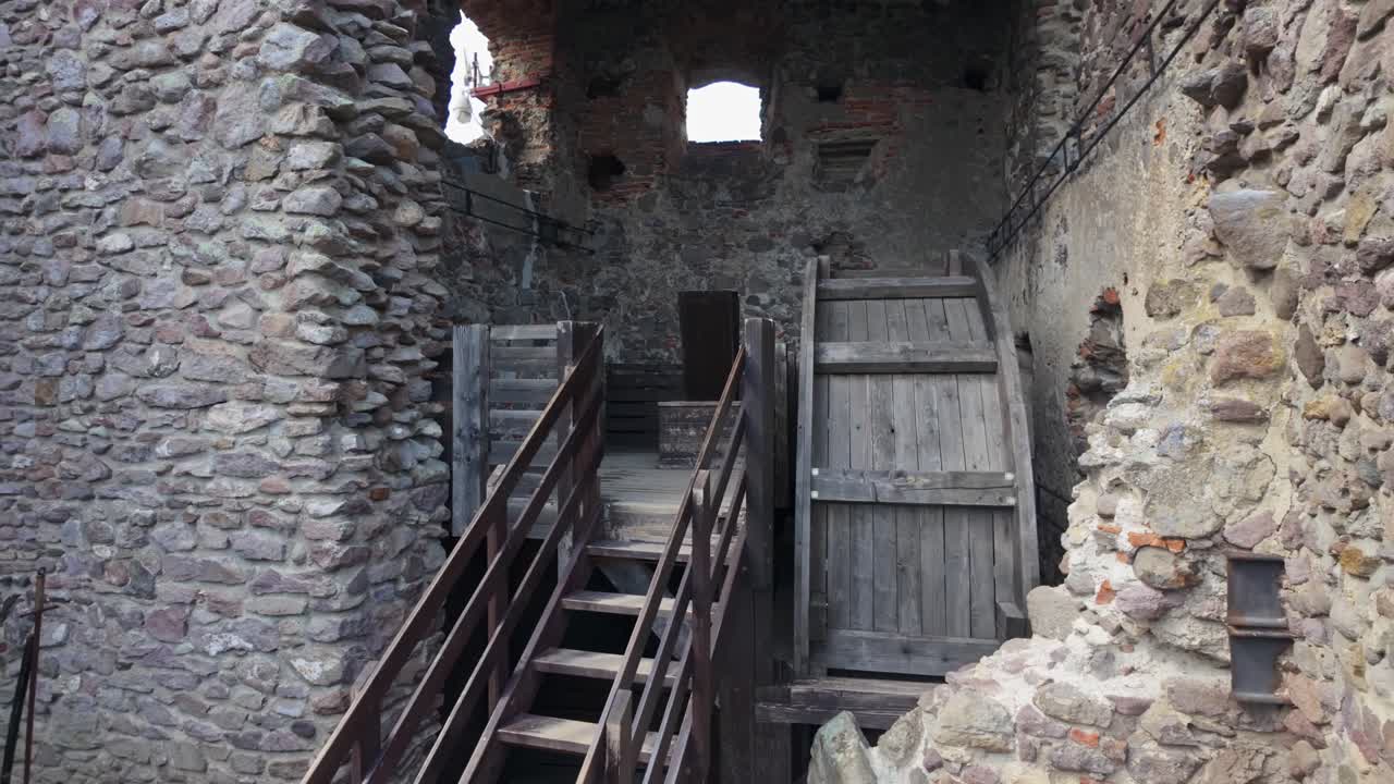 Pull-back shot of Boldogkőváralja castle in Hungary, highlighting its wooden structure, stone walls, medieval ruins, and preserved historical architecture in a picturesque outdoor setting