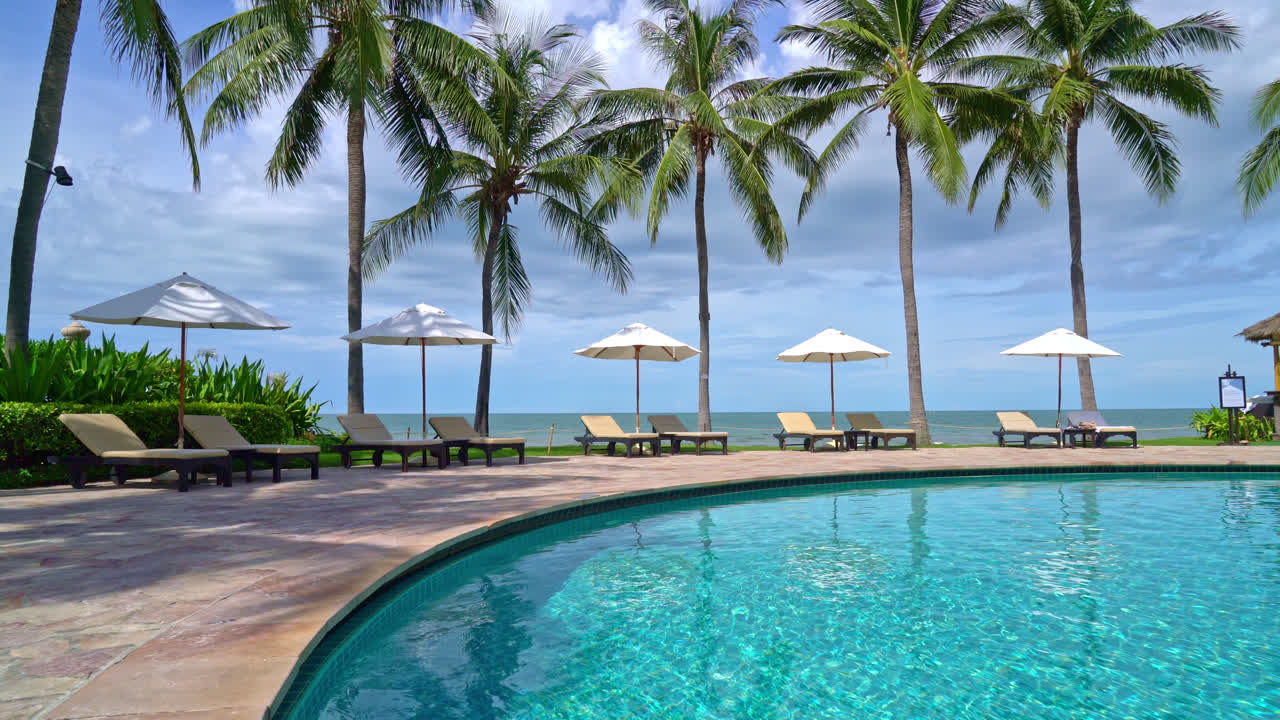 Smuk parasol og stol omkring swimmingpool i hotel og resort - ferie koncept