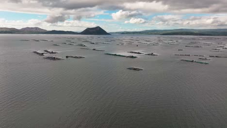 Rising-drone-shot-of-floating-fishing-cage-at-Taal-Lake,-Philippines