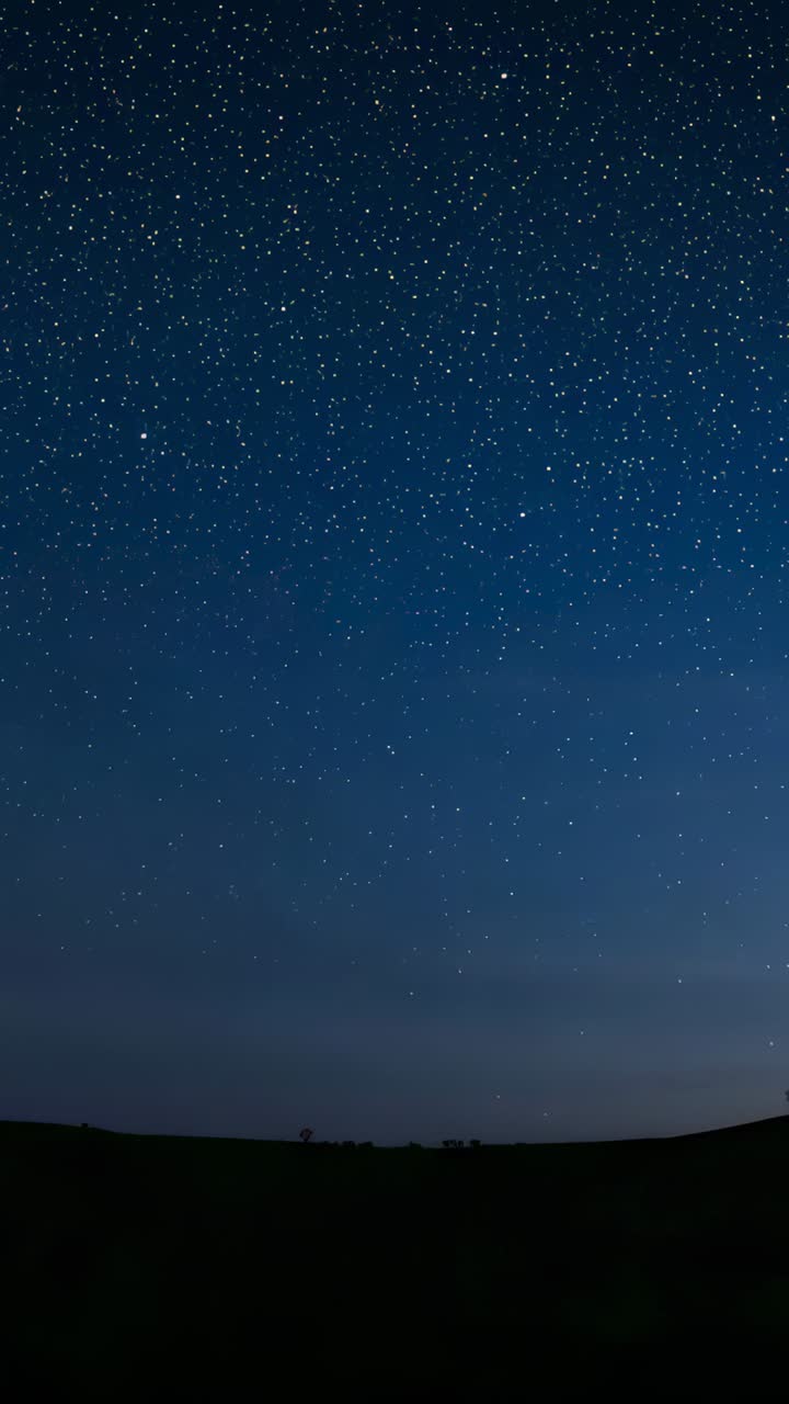Vertical video: Frames advancing revealing bright star field over rural hills, Milky Way emerging