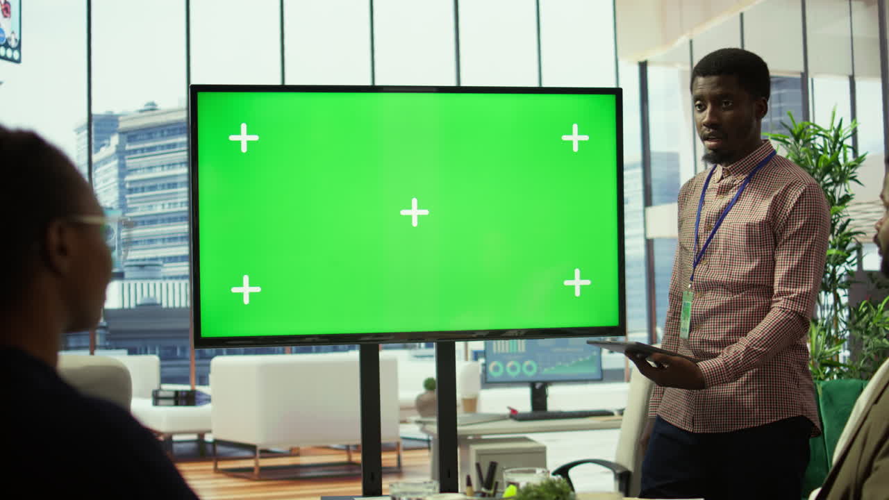 un equipo diverso de asociados de negocios mirando la pantalla clave de chroma de maqueta