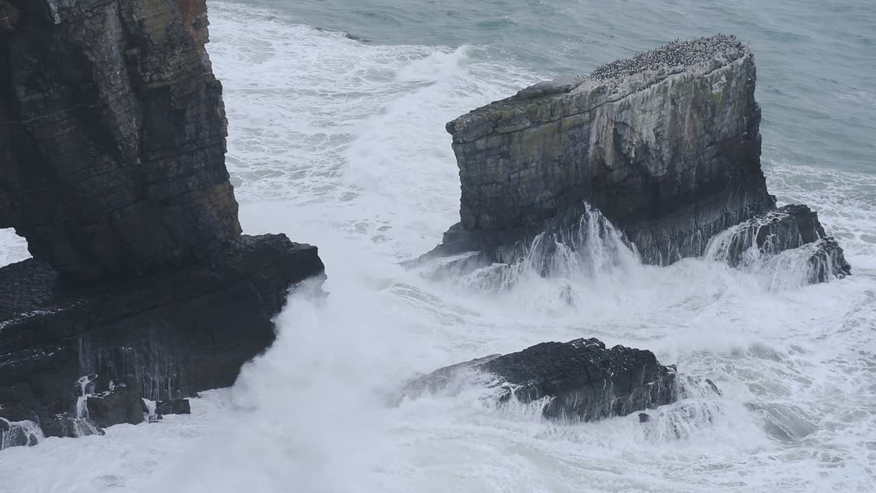 Waves Crashing On The Rocky Cliff In Pembrokeshire, Wales - Aerial Shot