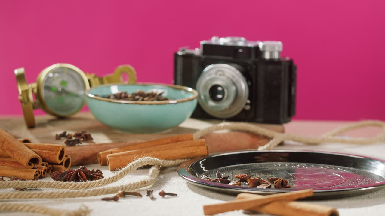 Anice stellato versato a mano da un sacco di juta con spezie e macchina fotografica vintage