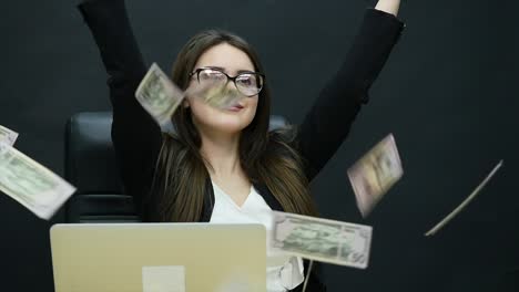 beautiful young businesswoman is counting money, fanning herself with dollars, laughing and throwing them in the air