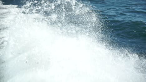 close up of ocean sea white foamy waves behind boat