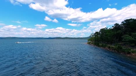 Wunderschöne-DJI-Phantom-Drohnenaufnahme-Eines-örtlichen-Sees,-An-Dem-Ein-Boot-Vorbeifährt