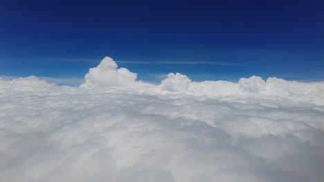 Fliegen-über-Weichen,-Flauschigen-Weißen-Baumwollwolken-Gegen-Den-Blauen-Himmel