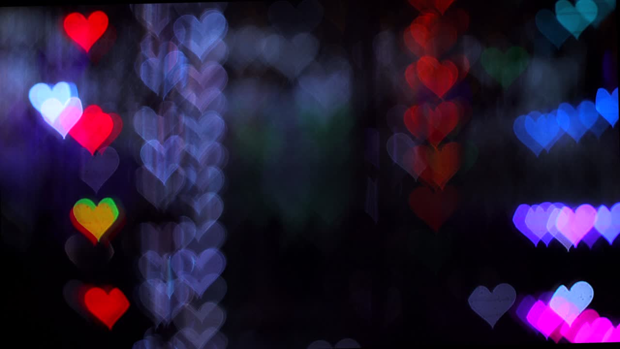 4k uhd video de fondo para el día de san valentín. frontera con bokeh de corazones románticos brillantes y relucientes un fondo gris oscuro. amor, bokeh en forma de corazón.
