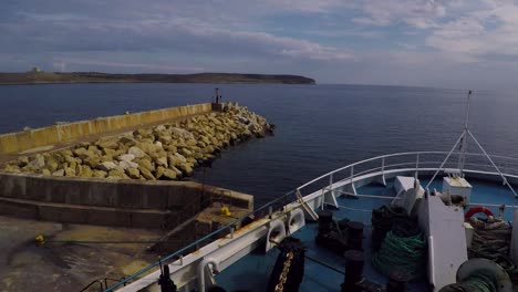 ferry boat waiting on a port in malta, looking toward an island