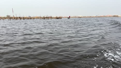 Paseos-En-Bote-Por-El-Lago-Africano-Nokoue,-Vista-De-La-Estela-Desde-El-Bote