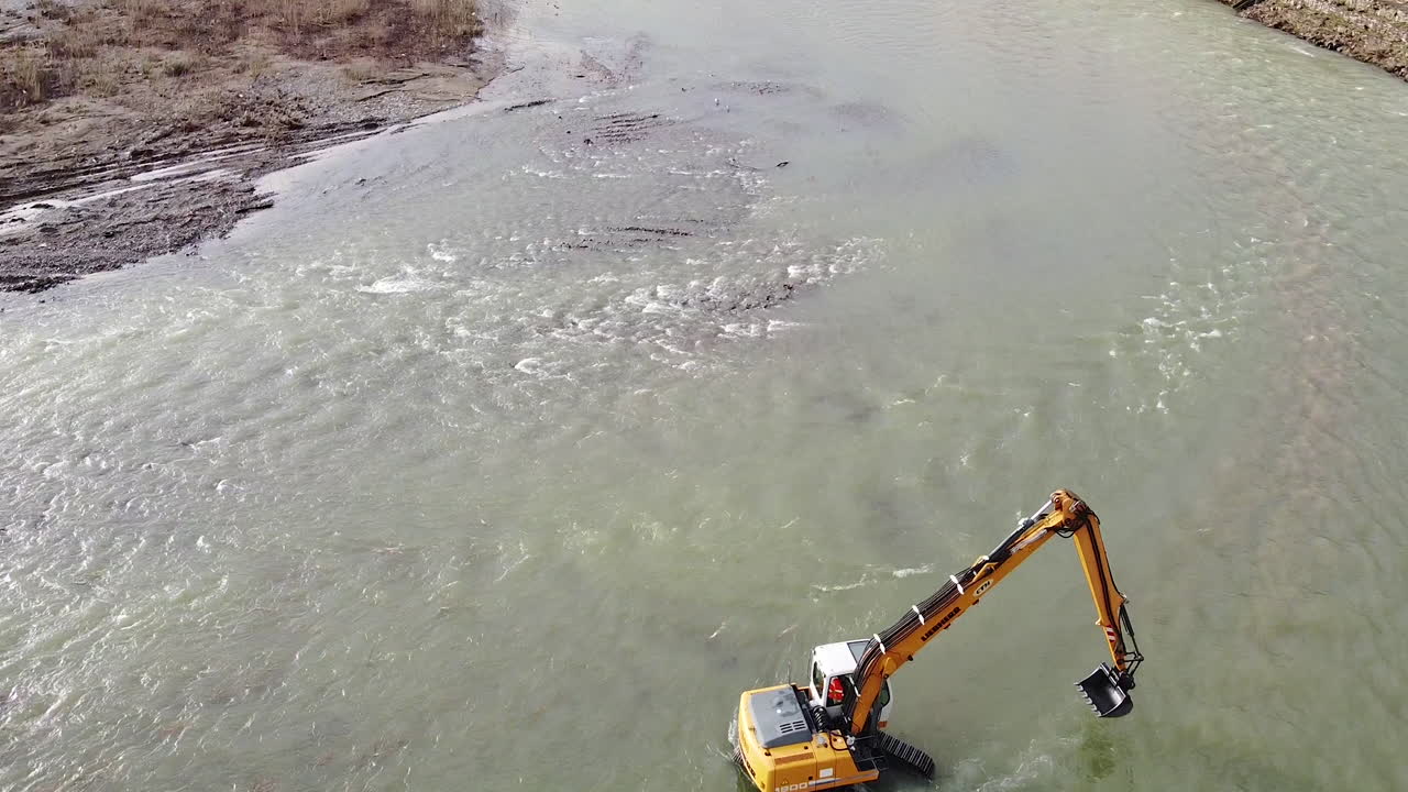 vista hacia atrás excavadora de agua trabajando dentro del río arno cerca de la ciudad de sieci, pontassieve, para evitar otra inundación por desastre de florencia después de la última temporada de lluvias de noviembre