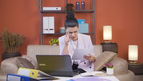 Home-office-worker-young-woman-examining,-analyzing-documents.