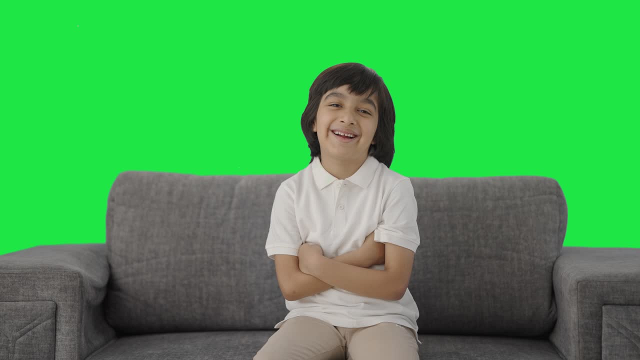 niño indio feliz riendo en la pantalla verde de la cámara
