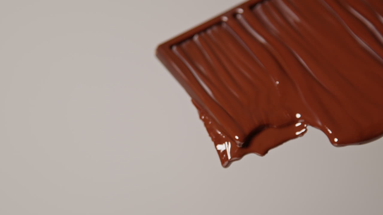 primer plano de una barra de chocolate derretida contra un fondo blanco con espacio de copia 1