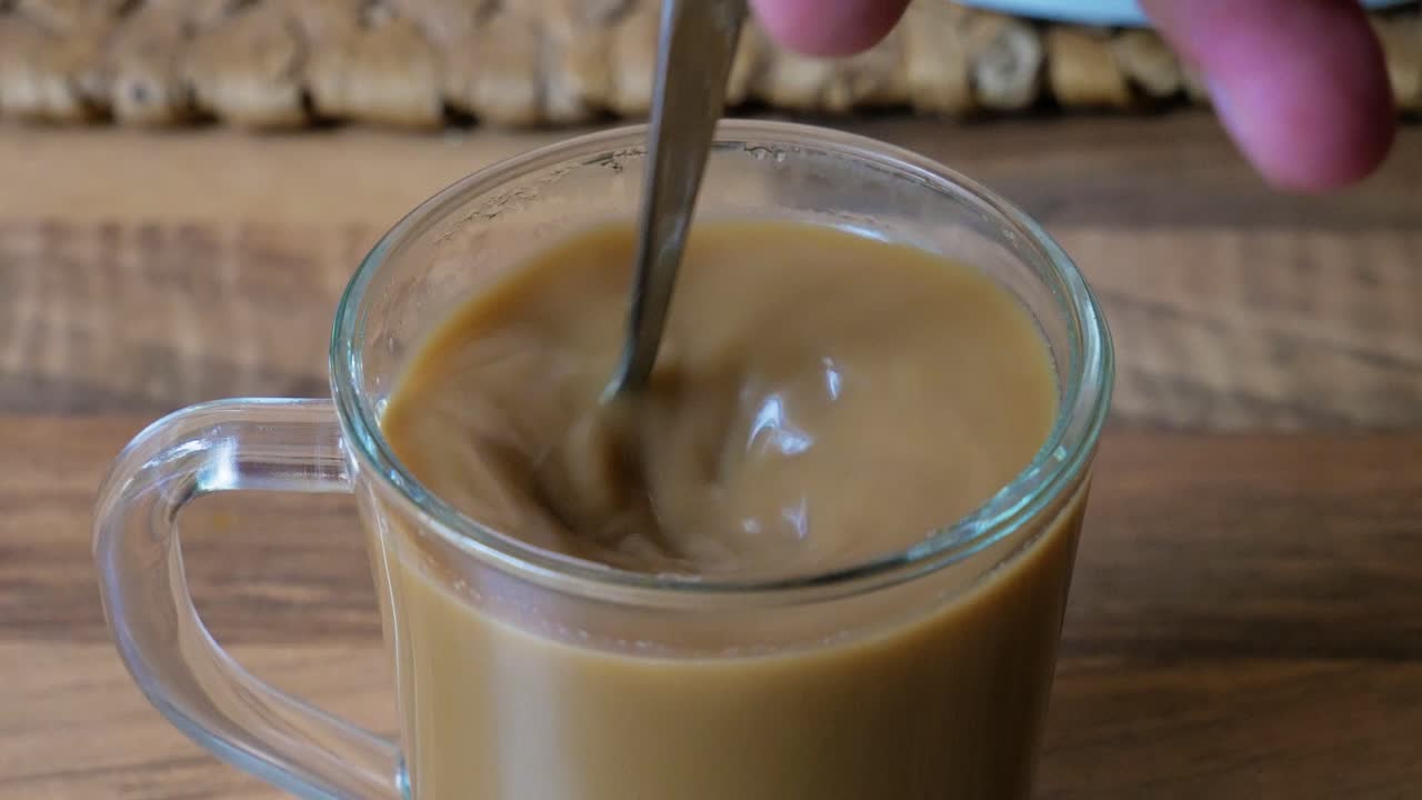 Mescolando una tazza di caffè bianco istantaneo in primo piano