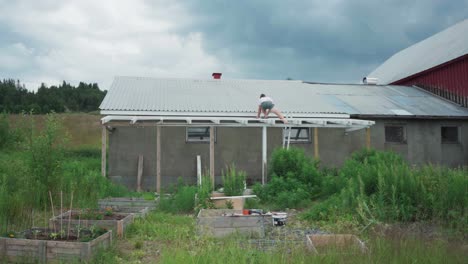 hombre instalando una extensión de techo fuera de la casa en el paisaje rural