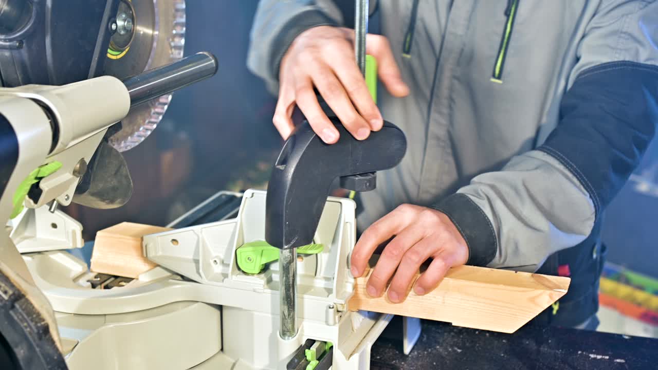 un joven carpintero instala una pieza de madera en una sierra circular.