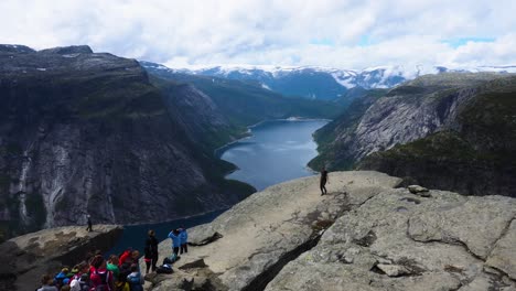 people are posing at the trolltunga to take epic photo risking thier lives in norway