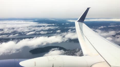 view from over airplane wing flying over clouds