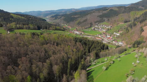 Vista-Aérea-De-Un-Pequeño-Pueblo-En-Un-Valle-Rodeado-De-Colinas-Y-Bosques-De-La-Selva-Negra,-Alemania