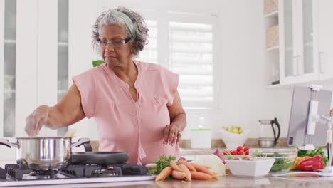 Happy-senior-african-american-woman-cooking-in-kitchen