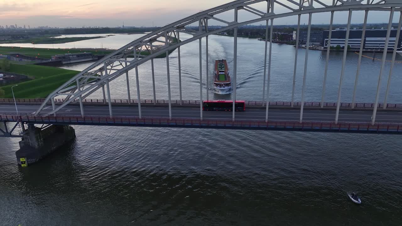 coches conduciendo a través del puente de arco con un crucero fluvial navegando en el río noord al atardecer en hendrik-ido-ambacht, países bajos