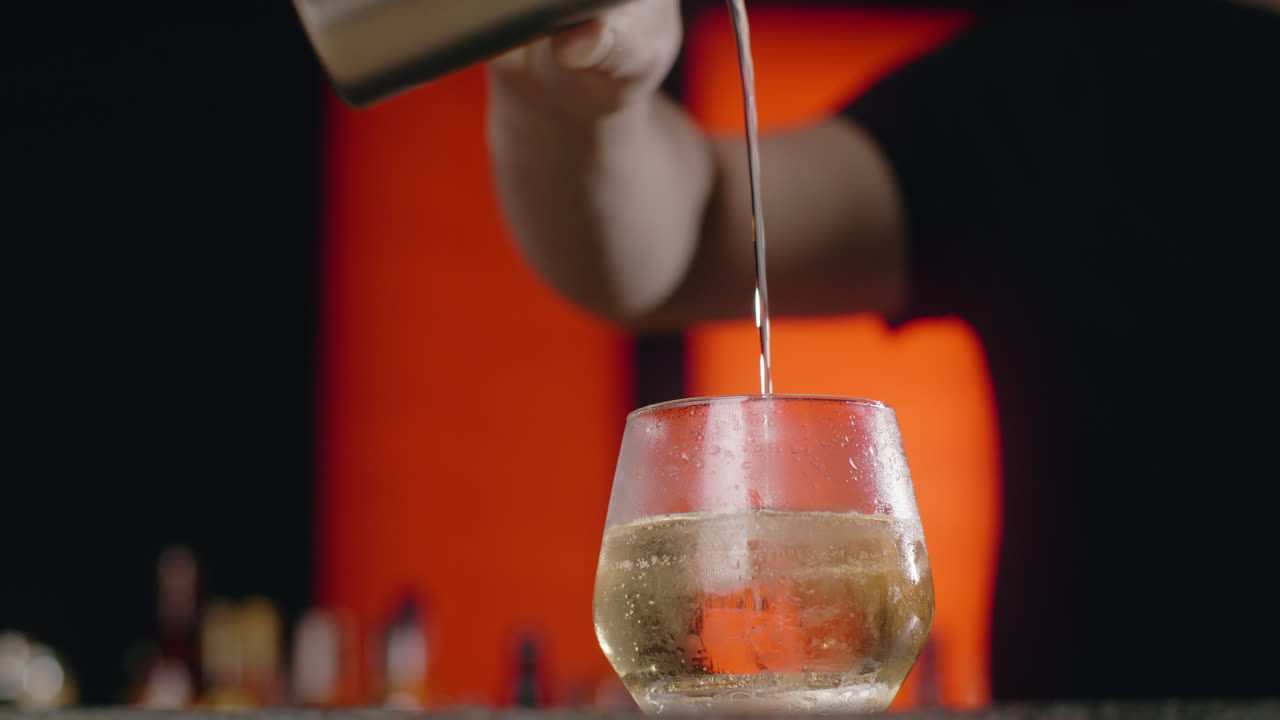 el camarero vertiendo un cóctel.