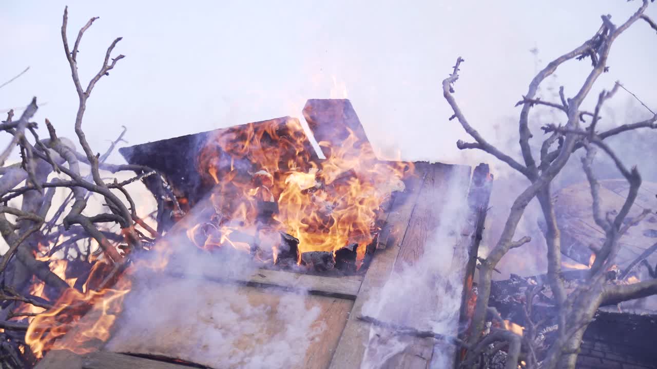 old wooden doors are burning in the fire with dry branches