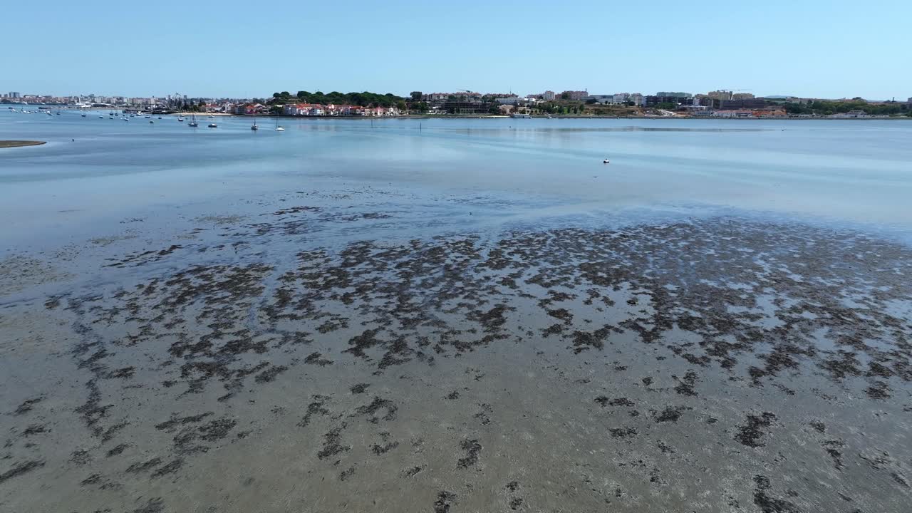 Drone shot flying over some dirty and shallow water in Portugal