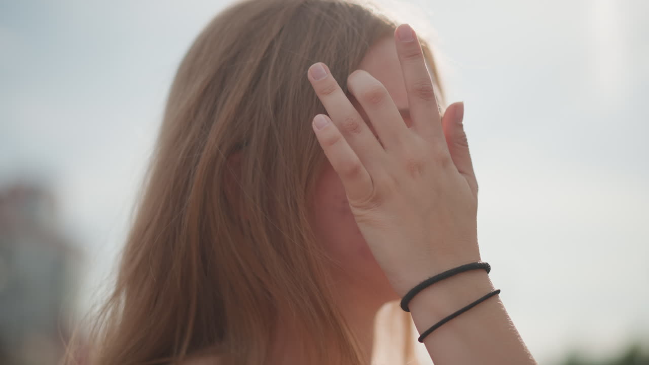 Jonge vrouw danst in een zonovergoten straat, gooit met haar hoofd en lacht speels, wapperend haar vangt de wind, ritmische beweging tegen bakstenen architectuur, opgewekte filmische toon, influencer-reel of reclamespot b