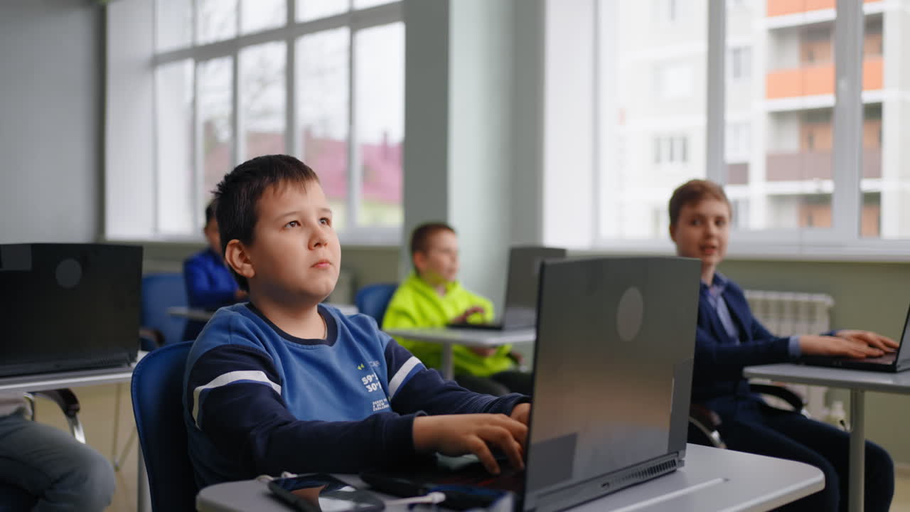 estudiantes en un aula con computadoras portátiles