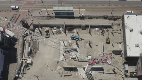 Dron-Volando-Sobre-Una-Grúa-Torre-De-Pluma-Abatible-En-Un-Sitio-De-Construcción-En-Tacoma,-Washington