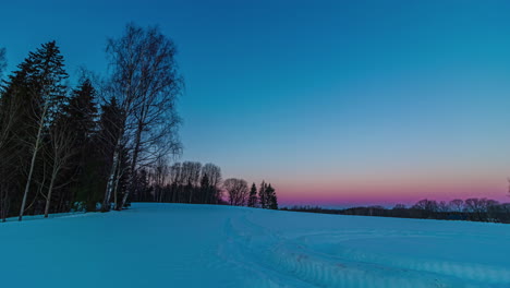 sky changes to vibrant colours as day breaks over snowy area