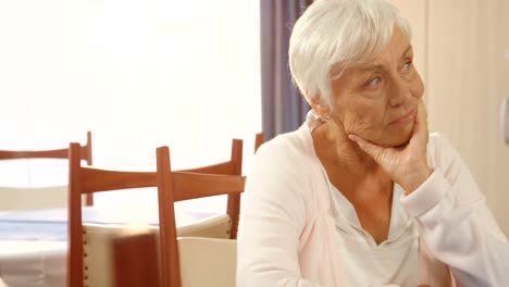 Unhappy senior woman sitting alone